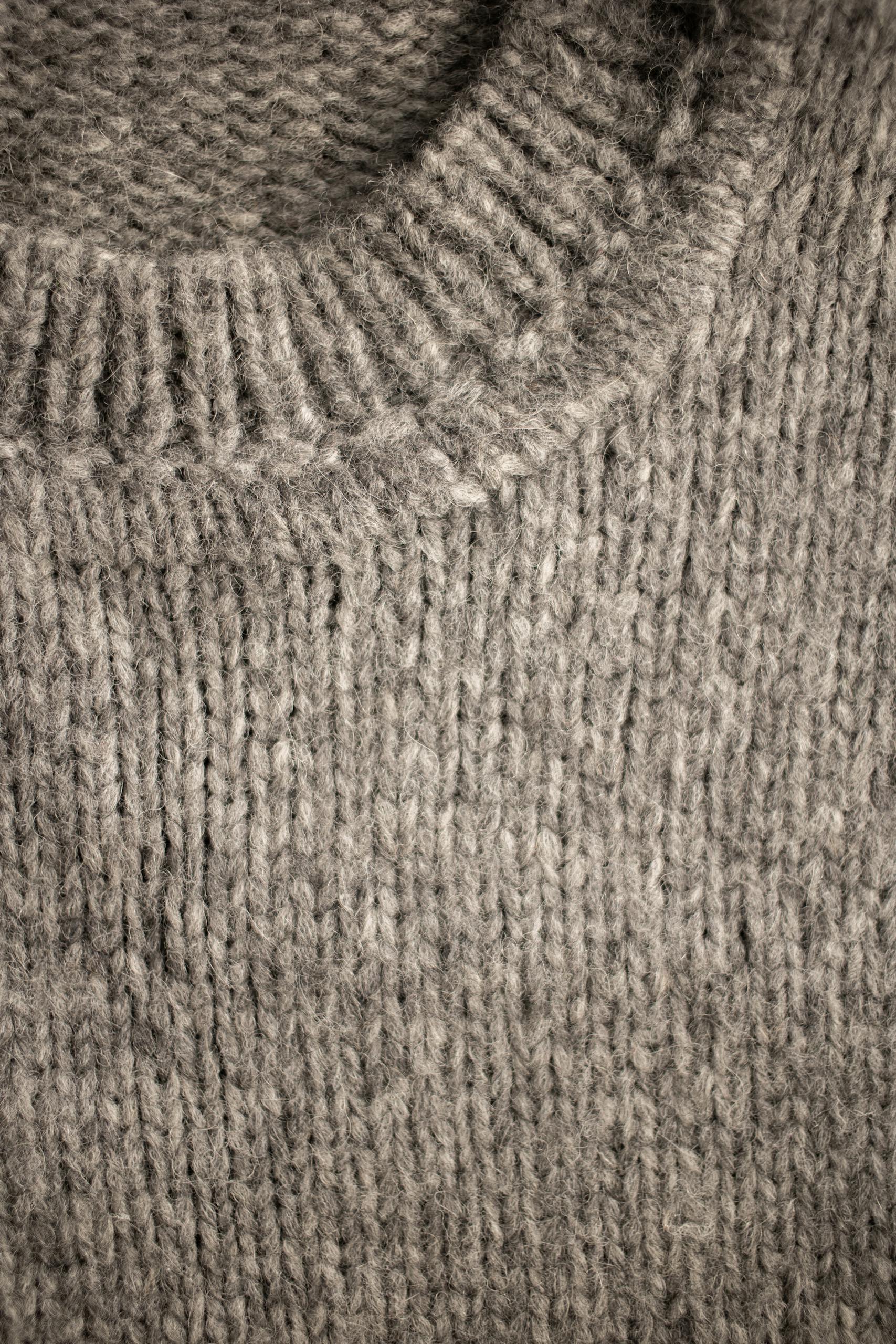 Detailed closeup of a knitted wool sweater texture for cozy fashion designs.